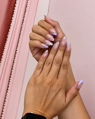 Almond nails in lilac and nude with gold striping and two leopard-print accent nails