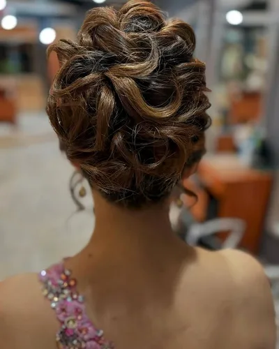 The back of a full curled updo, pinned loosely with highlights running through it