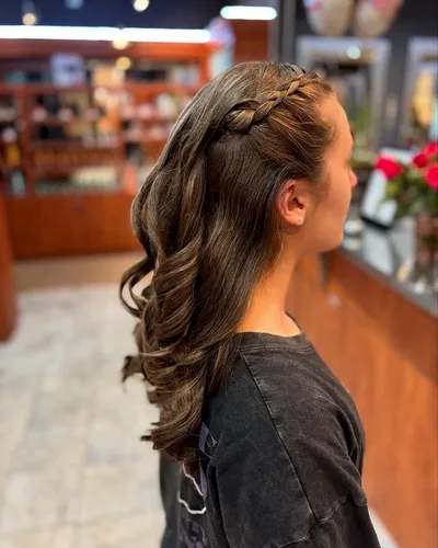 A crown braid leading into long loose curls on a young client